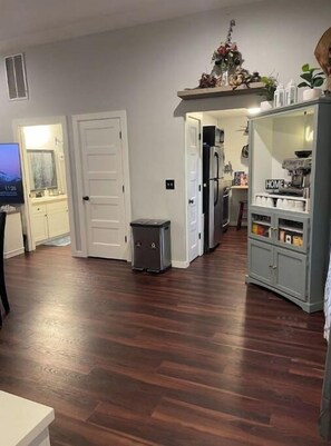 Relax in this comfortable living area with a mounted TV, storage, and a convenient trash bin.