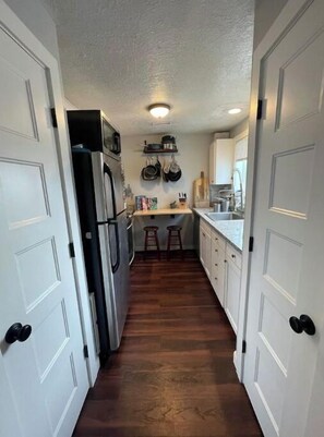 Enter a well-appointed kitchen with a sink, stove, and refrigerator, plus ample storage for kitchen essentials.
