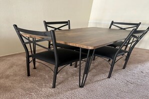Enjoy meals in a cozy dining area with a rectangular table and four comfortable chairs.