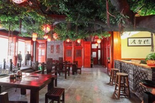 An indoor dining area with wooden tables and chairs, a bar counter, and traditional decor.