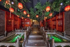A traditional Chinese-style corridor with wooden doors, lanterns, and a central water feature. - Dexinju Hostel (Shennongjia)