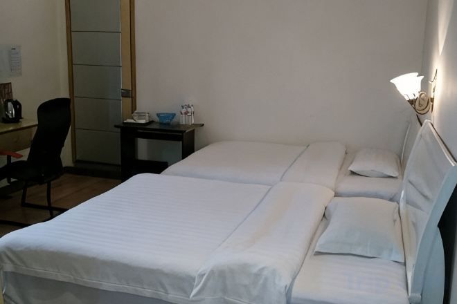 A room with two beds, a desk, and a chair.