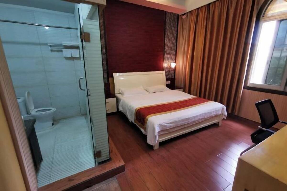 Une chambre d’hôtel équipée d’un lit, d’un bureau, d’une chaise, d’une douche et de toilettes.