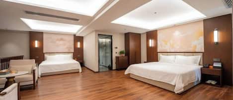A modern hotel room with two beds, a sitting area, and a large window.
