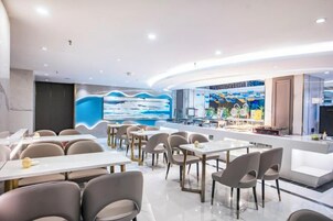 Un restaurante moderno con una barra curva, varias mesas y sillas.