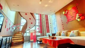 Una habitación de hotel moderna con sofá, una mesa y una escalera.