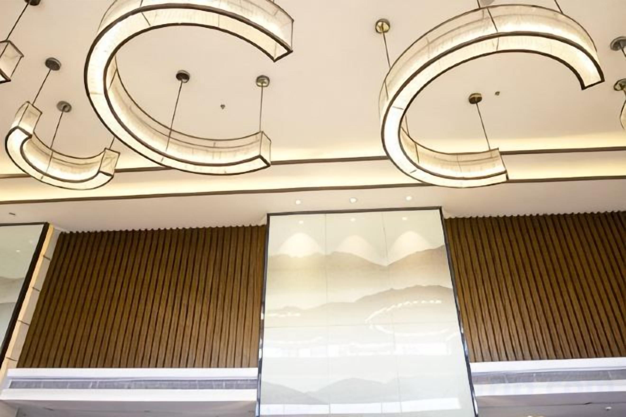 A ceiling with large, illuminated letters and a large window with a view of a landscape.