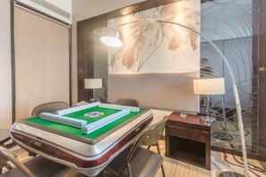 A room with a pool table, two chairs, a lamp, and a large abstract painting on the wall. - Yi Jia Hotel (Zhuhai)