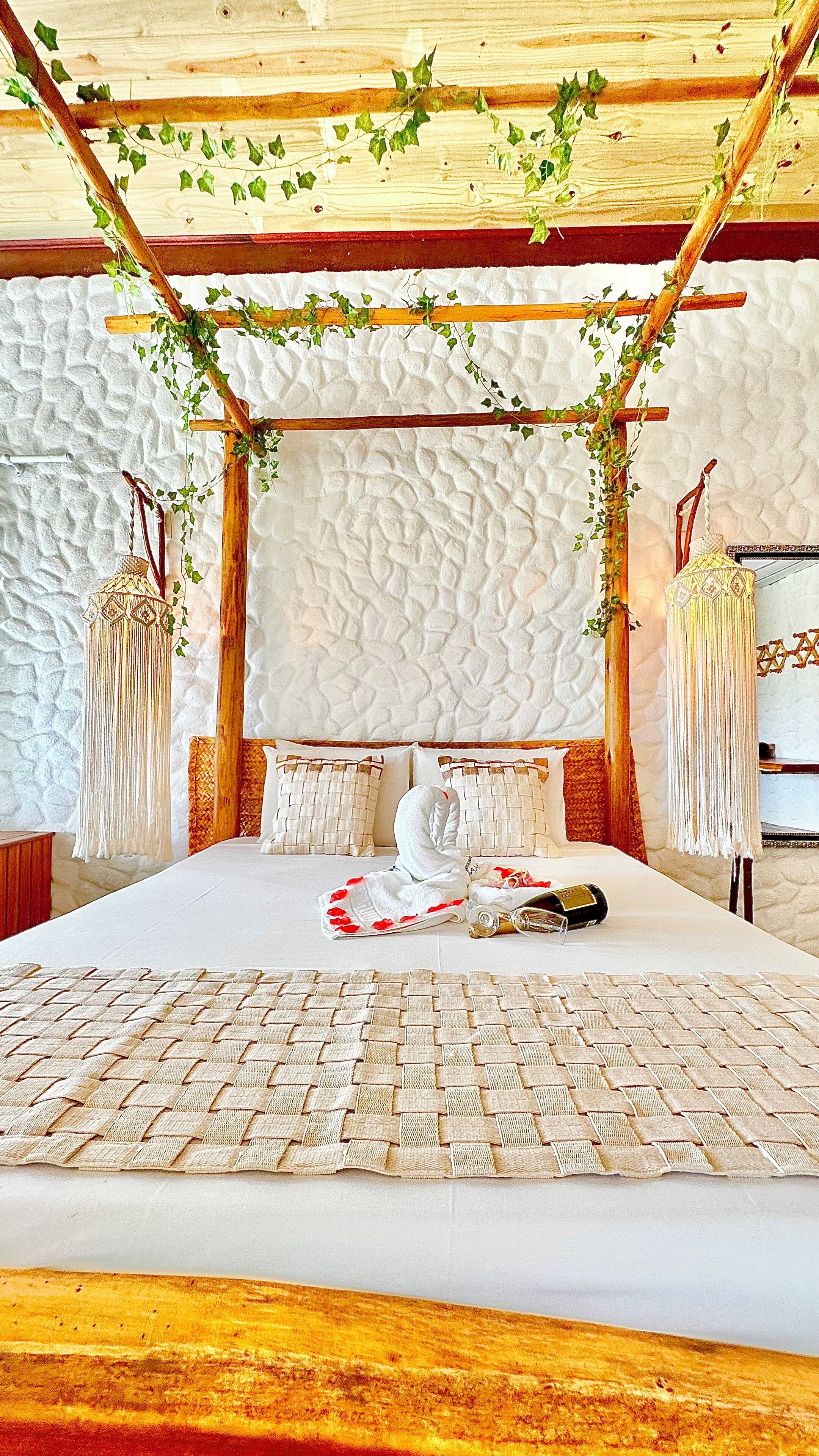 A bed with a white canopy, a woven headboard, and a decorative hanging.