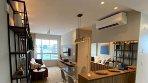 Una cocina moderna con una isla central, estantes empotrados y un área de comedor con un sofá y sillas.