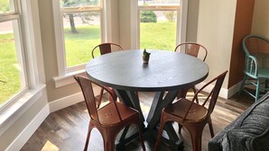 A round table with four chairs in a room with large windows. - Unique downtown Fruita apartment with bike storage! (Fruita)