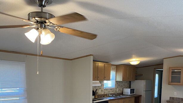 A spacious kitchen with wooden cabinets, a dishwasher, and a ceiling fan. - Centrally located to all North Florida Hot spots (Interlachen)