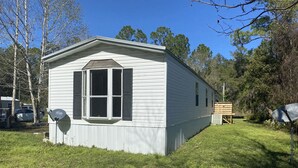 A small, single-story house with a gabled roof and a large window. - Centrally located to all North Florida Hot spots (Interlachen)