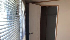 A room with a wooden floor, a white door, and a window with blinds. - Centrally located to all North Florida Hot spots (Interlachen)