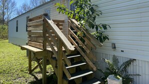 A wooden staircase leading to a mobile home with a small porch area. - Centrally located to all North Florida Hot spots (Interlachen)