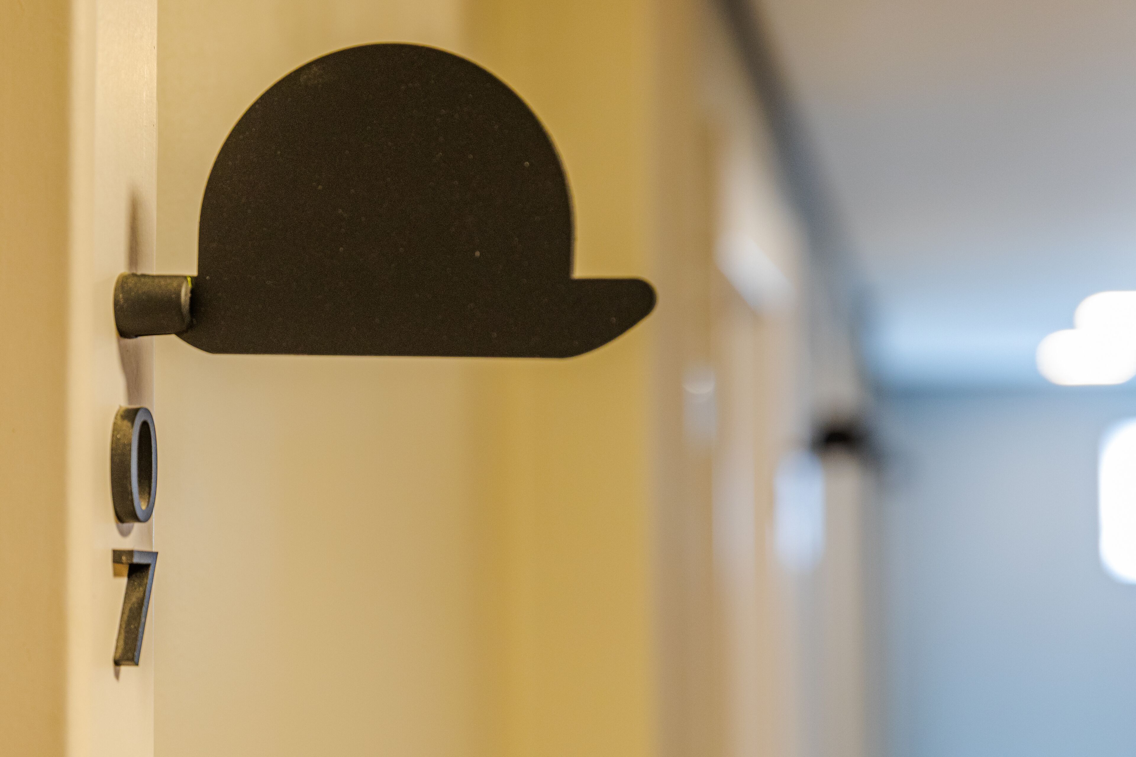 Une porte ornée d’un objet noir et incurvé, qui pourrait être un butoir de porte ou un élément décoratif.