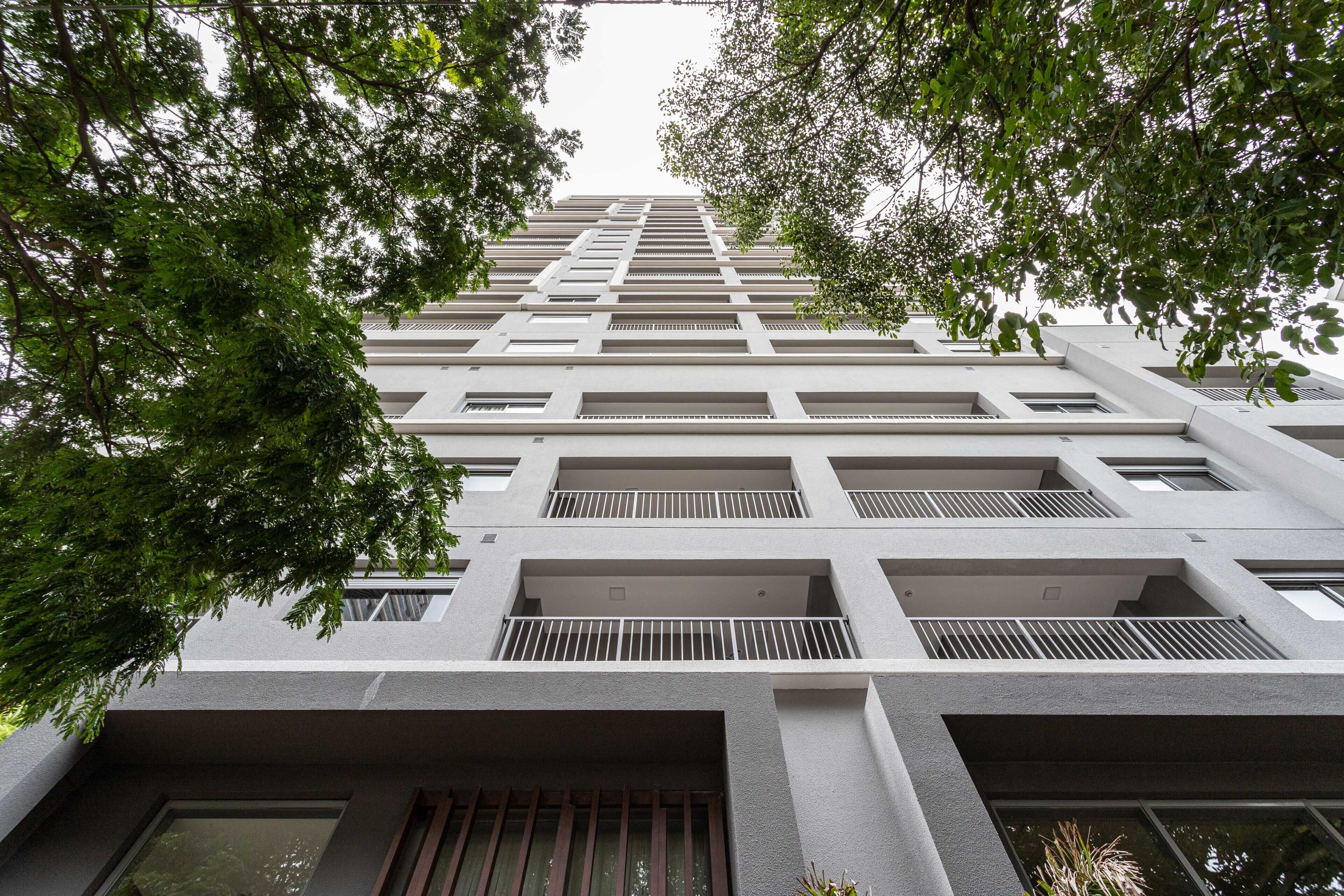 A modern high-rise building with multiple balconies and large windows.