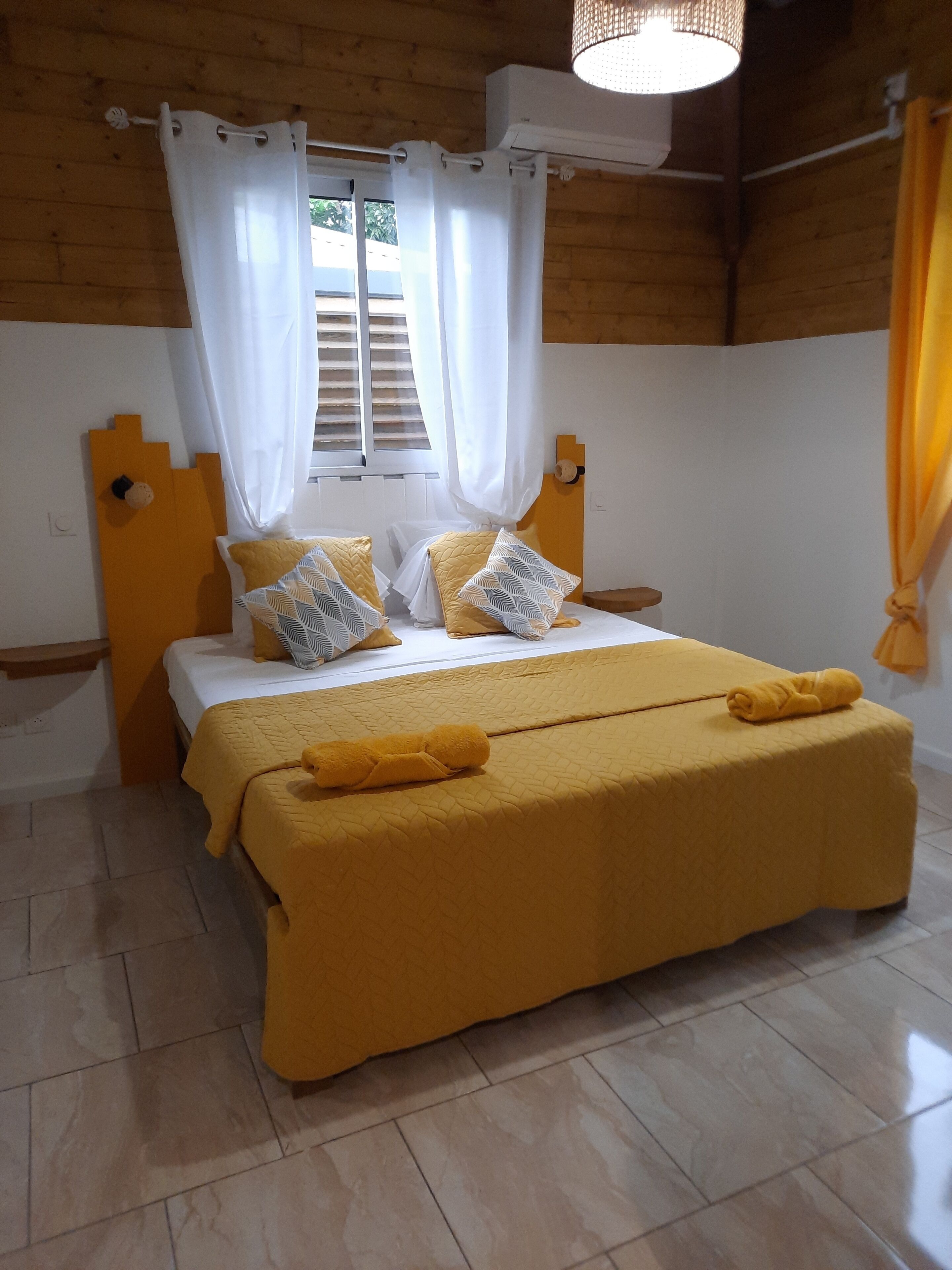 Un dormitorio con cama, cortinas y ventana.