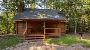 A log cabin with a porch and a green door, surrounded by trees. - Labor Day at The Summit - Wifi and Hot Tub! - Callaway Gardens (Warm Springs)