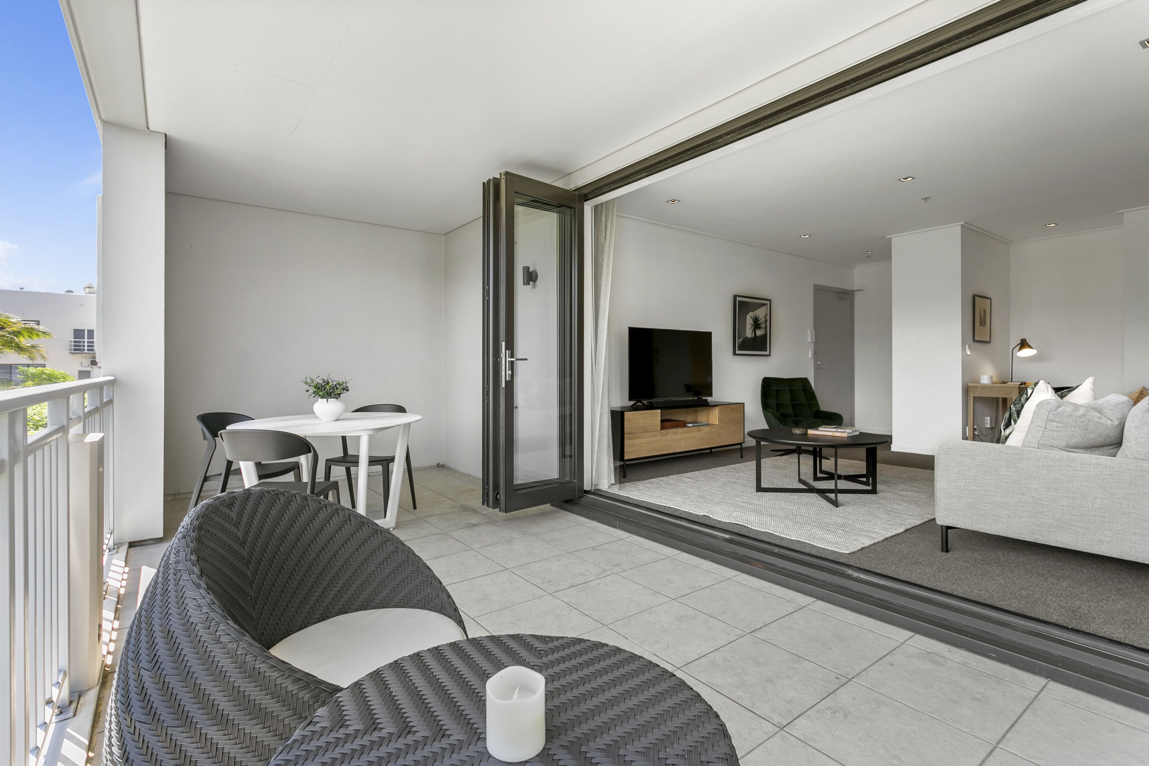 Un appartement moderne doté d’un balcon, d’un coin repas, d’un salon et d’un canapé.
