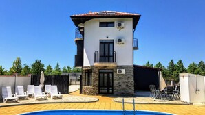 A two-story building with a swimming pool in front.