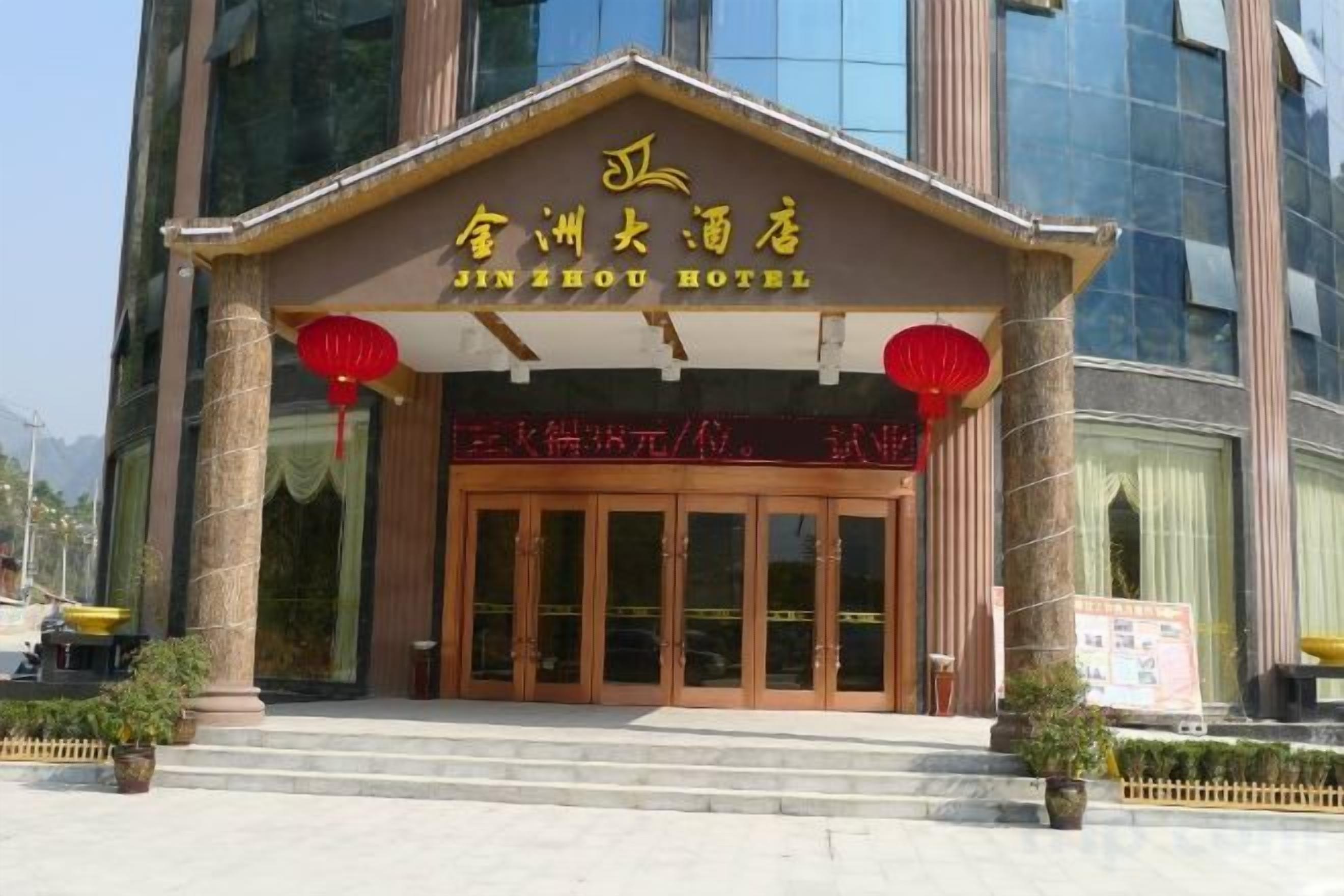 Ein Hotel Eingang mit traditioneller chinesischer Architektur, mit einer großen Holztür und roten Laternen.