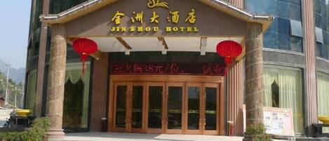 Ein Hotel Eingang mit traditioneller chinesischer Architektur, mit einer großen Holztür und roten Laternen.