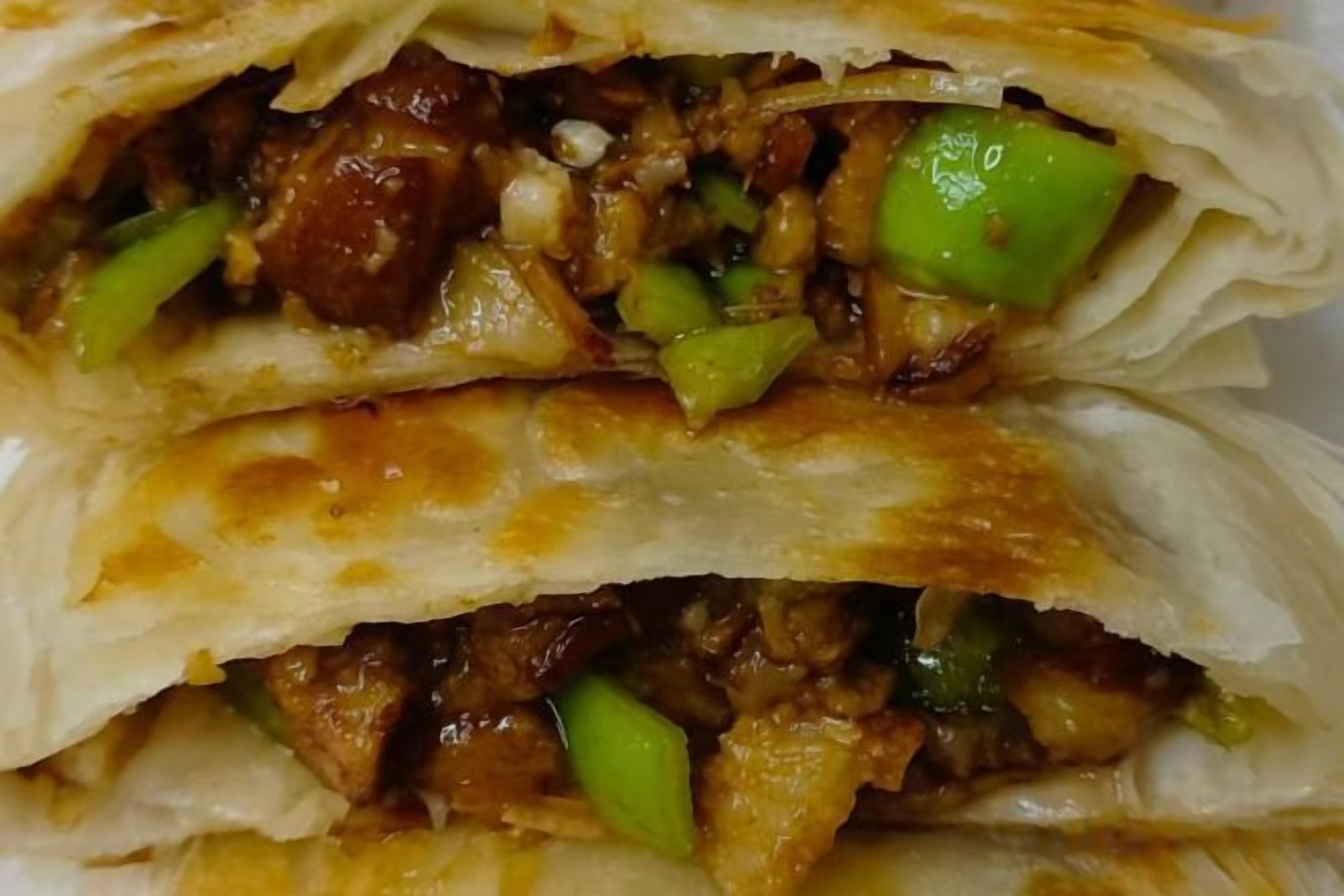 A stack of folded food items with visible fillings.