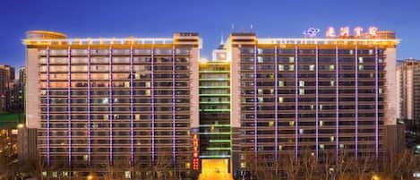 A multi-story hotel with a modern design, featuring a prominent signage at the top.