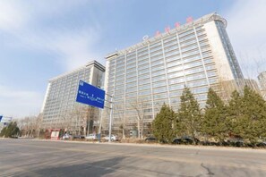 A large, modern hotel building with a prominent glass facade and signage indicating it is a Marriott hotel. - Qiangang Hotel (Qian'an)