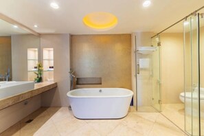 Ein modernes Badezimmer mit freistehender Badewanne, einer Duschkabine aus Glas und einem großen Spiegel.