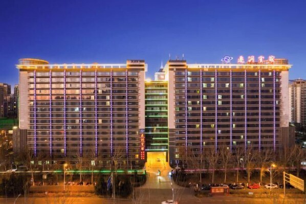 A multi-story hotel with a central entrance and balconies. - Qiangang Hotel (Qian'an)