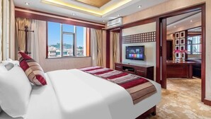 Une chambre d’hôtel avec un grand lit, un bureau, une télévision et une vue sur la ville.
