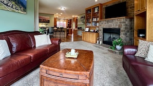 A living room with a leather sofa, a coffee table, a fireplace, and a television. - Liberty Hill Lodge, Hot Tub & Pool (New Philadelphia)