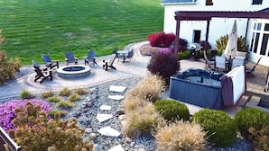 A patio area with outdoor seating, a hot tub, and a fire pit. - Liberty Hill Lodge, Hot Tub & Pool (New Philadelphia)