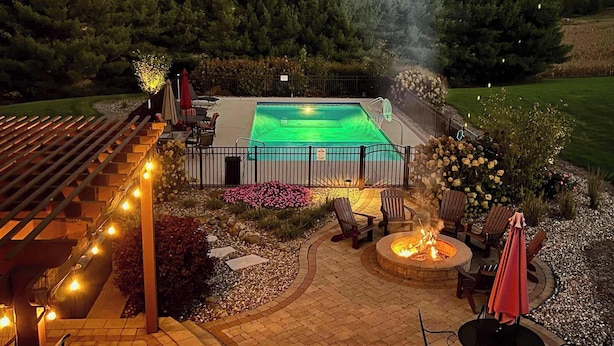 A backyard with a swimming pool, outdoor seating, and a fire pit. - Liberty Hill Lodge, Hot Tub & Pool (New Philadelphia)