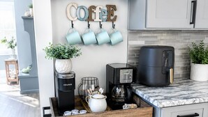 A kitchen with a coffee station, a Keurig coffee maker, a coffee machine, and a marble countertop. - Modern Poconos Cabin w/ Hot Tub Near Kalahari & CamelBack Mountain ! (Long Pond)