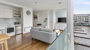 A modern apartment with a kitchen, living area, and balcony. - Light and convenient city living (Auckland)