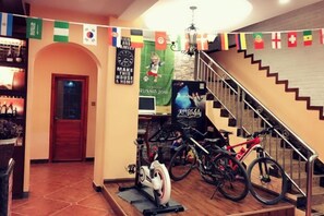 A room with a staircase, a stationary bike, and a bicycle. - Jiuqi Our House (Zhangjiajie)