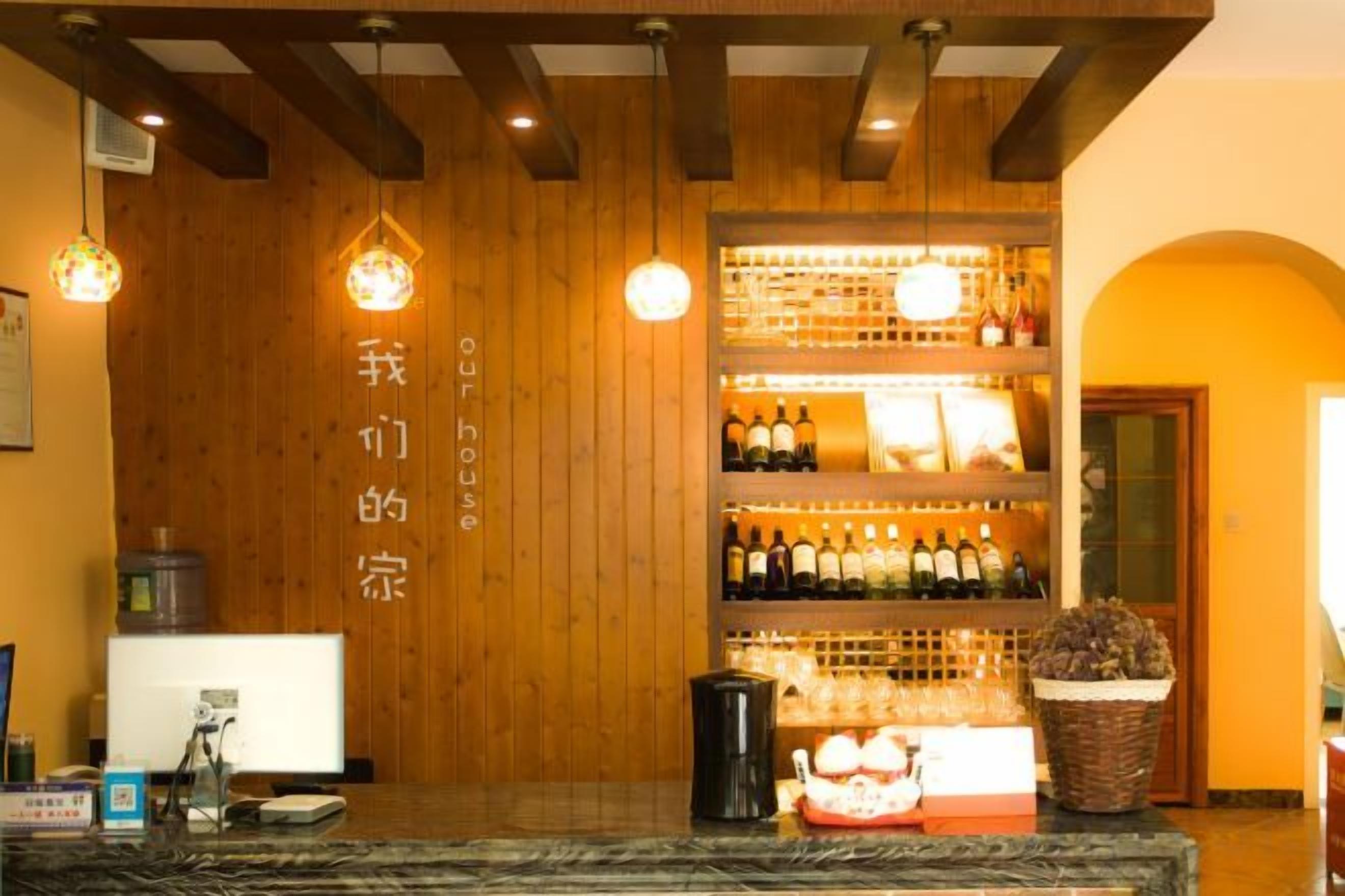 Una zona de bar con paredes de madera, estantes llenos de botellas y una barra.