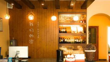 Una zona de bar con paredes de madera, estantes llenos de botellas y una barra.
