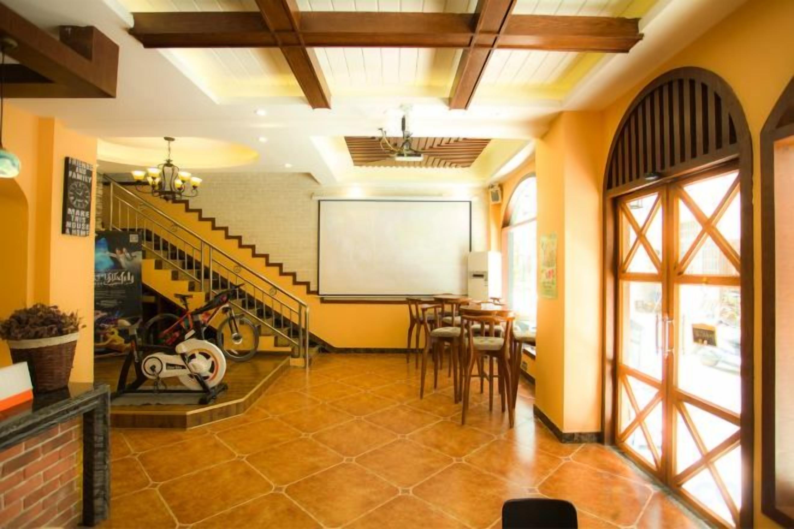 A hotel lobby with a staircase, a reception desk, and a large window with a view.