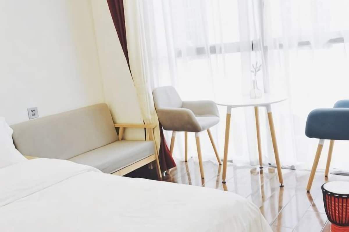 Een hotelkamer met een bed, een bank, een ronde tafel en twee stoelen.