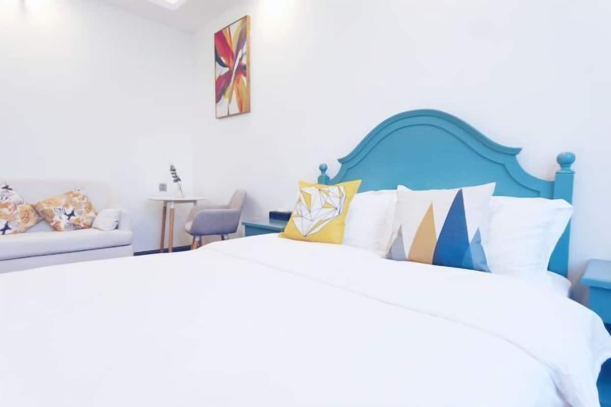 Een hotelkamer met een groot bed, een bank, een tafeltje en een stoel.