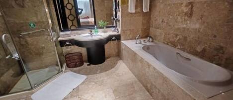 Un baño con cabina de ducha de vidrio, un lavabo, una bañera y un espejo.