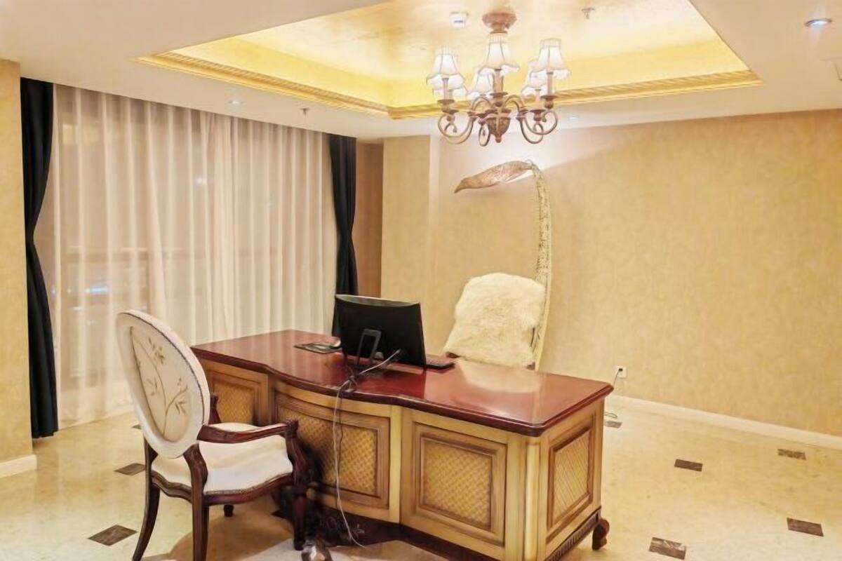 Una habitación bien iluminada con un escritorio, una silla y una lámpara.