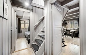 Staircase leads to an upper level, with a dining area and artwork-adorned walls.