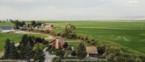 Ein ländliches Anwesen mit einem großen Haus, einer kleinen Hütte und einer eingezäunten Weide.