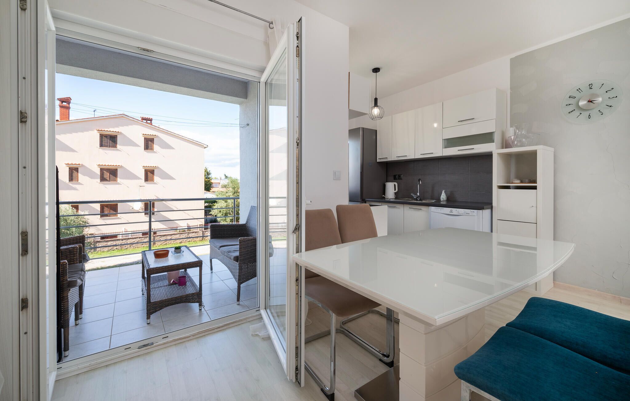 A modern apartment with a balcony, a kitchen, and a dining area.