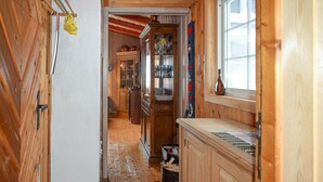 A narrow wooden hallway with a kitchen area on the right, featuring cabinets, a sink, and a window with a view. - Awesome home in Ustaoset with WiFi (Ustaoset)